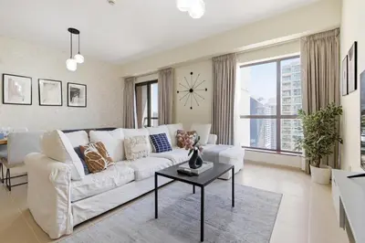 a living room with a white couch and a clock at Rimal 1, JBR - 2 Bedroom Apartment - Allsopp & Allsopp in Dubai