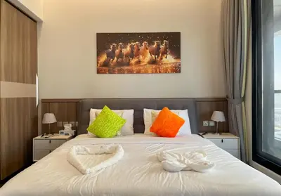 a bedroom with a bed with colorful pillows at Brand New Two Bedrooms Apartment With Amazing Marina View in Dubai