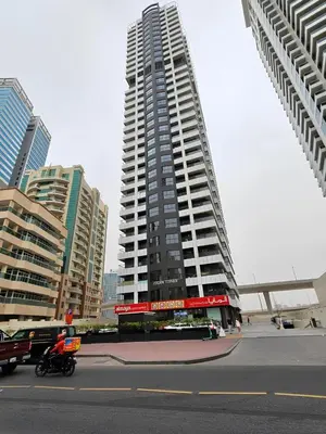 a tall building with a person on a motorcycle in a city at Brand New Two Bedrooms Apartment With Amazing Marina View in Dubai