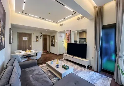 a living room with a couch and a tv at Brand New Two Bedrooms Apartment With Amazing Marina View in Dubai
