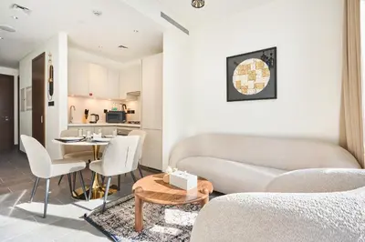 a living room with a couch and a table at STAY BY LATINEM Luxury 1BR Holiday Home CC 0302 Near Burj Khalifa in Dubai