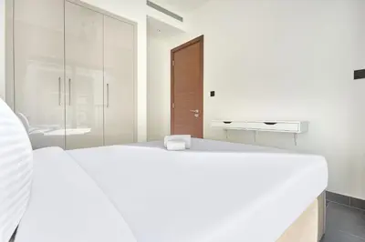 a white bedroom with a large bed and a glass wall at STAY BY LATINEM Luxury 1BR Holiday Home CC 0302 Near Burj Khalifa in Dubai