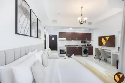 a white living room with a couch and a kitchen at Vogue Business Bay Court Tower close to Downtown Burj Khalifa and Dubai Mall, Studio Apartment with City view in Dubai
