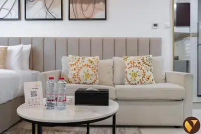 a living room with a couch and a table with water bottles at Vogue Business Bay Court Tower close to Downtown Burj Khalifa and Dubai Mall, Studio Apartment with City view in Dubai
