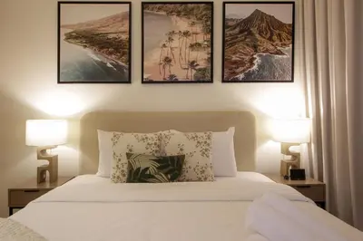a bedroom with a bed with four pictures on the wall at Silk Valley - Luxury St with Pool Access & Balcony | 10 Min to Downtown in Dubai