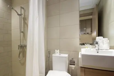a bathroom with a shower and a toilet and a sink at Silk Valley - Luxury St with Pool Access & Balcony | 10 Min to Downtown in Dubai