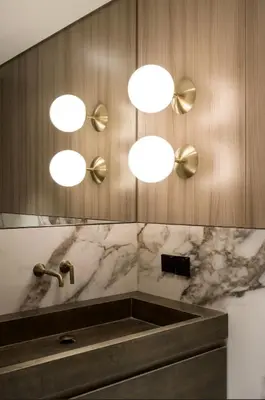 a bathroom with a sink and three lights on the wall at Luxurious 3br apartment Dubai mall in Dubai