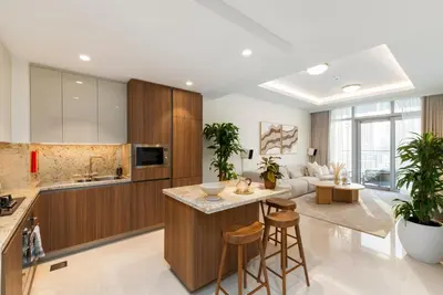 a kitchen with wooden cabinets and a living room at Imperial Avenue, Downtown Dubai - The Mint Stay in Dubai