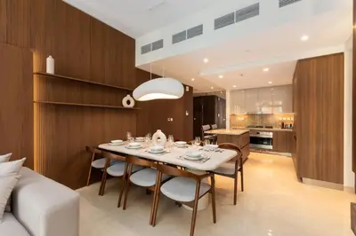 a dining room with a table and chairs and a kitchen at Imperial Avenue, Downtown Dubai - The Mint Stay in Dubai