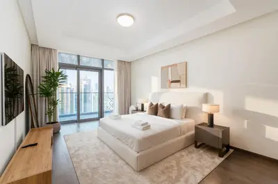 a white bedroom with a bed and a large window at Imperial Avenue, Downtown Dubai - The Mint Stay in Dubai
