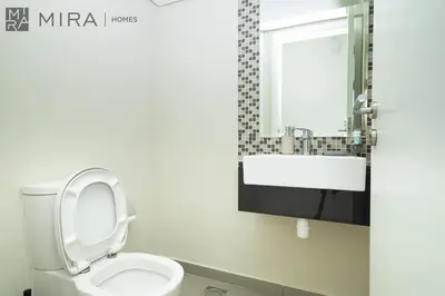 a bathroom with a toilet with a sink and a mirror at Mira Holiday Homes - Spacious 3BDR Villa Stylish & Modern Comfort in Dubai