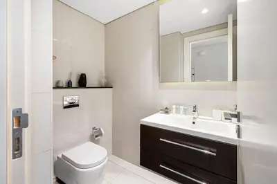 a bathroom with a toilet and a sink and a mirror at Luxury Unit High Floor Damac Majestine in Dubai