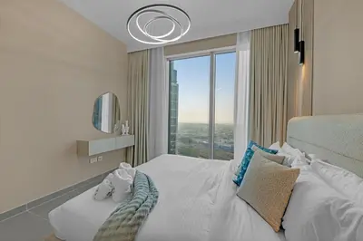 a bedroom with a white bed with a large window at 2BR Luxury Apartment in Downtown Opera in Dubai