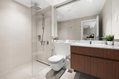 a bathroom with a toilet and a shower and a sink at La Mer Le Pont 1 Bedroom Beachside Apartment in Dubai