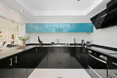 a kitchen with black cabinets and a blue counter top at Modern Luxury Upgraded 2BR Apartment The Greens in Dubai
