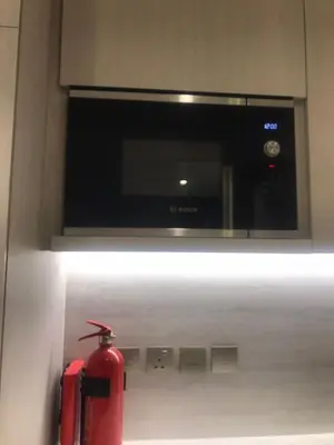 a red fire hydrant sitting under a microwave oven at Luxury Furnished Studio with Alexa Automation JVC in Dubai