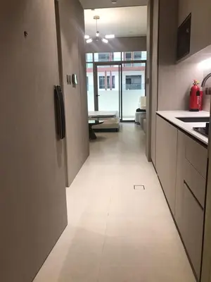 a kitchen with a hallway leading to a living room at Luxury Furnished Studio with Alexa Automation JVC in Dubai
