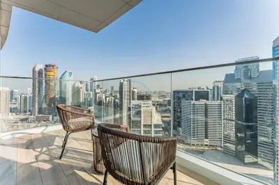 a balcony with two chairs and a view of the city at Walking Distance to Dubai Mall and Burj Khalifa, Easy Access to Dubai Marina, JBR Beach and Palm Jumeirah - Imperial Avenue, Downtown Dubai in Dubai