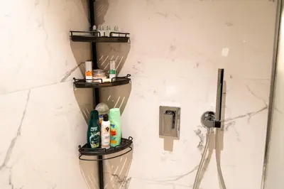 a bathroom with three shelves on the wall with shampoo and soap at 1Luxury Newbedroom nearBusiness Bay in Dubai