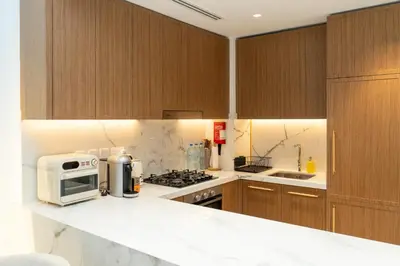 a kitchen with wooden cabinets and a microwave on a counter at 1Luxury Newbedroom nearBusiness Bay in Dubai