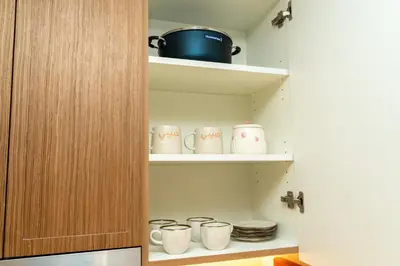 a cupboard with a bunch of mugs in it at 1Luxury Newbedroom nearBusiness Bay in Dubai