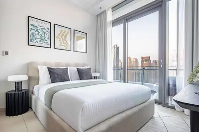 a bedroom with a large bed and a large window at Frank Porter - Silverene Towers in Dubai