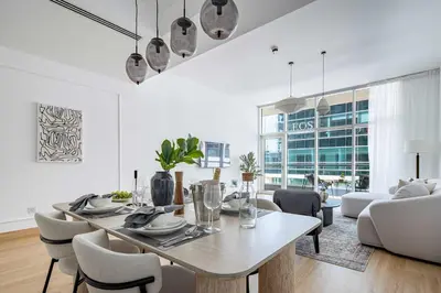 a white living room with a table and chairs at Frank Porter - Bay Square in Dubai