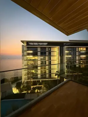 a building with a view of the ocean at sunset at Luxury Bluewaters Residence in Dubai