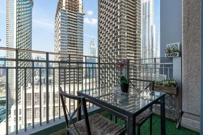 a table and chairs on a balcony with skyscrapers at Rustic Retreat in Standpoint, Heart of Downtown in Dubai