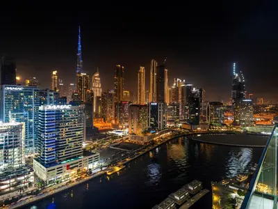 a city skyline at night with a river and buildings at Luxe studio Downtown Burj Khalifa Skyline view in Dubai