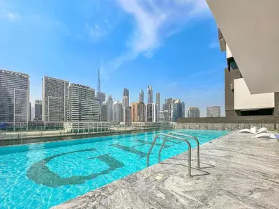 a swimming pool with a city skyline in the background at Luxe studio Downtown Burj Khalifa Skyline view in Dubai