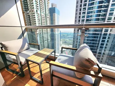a balcony with two chairs and a view of a city at Beautiful 1-BR next to Barasti Beach in Dubai