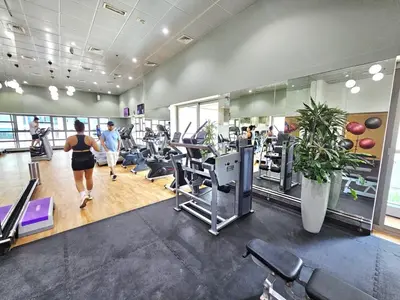 a gym with treadmills and people exercising in it at Beautiful 1-BR next to Barasti Beach in Dubai