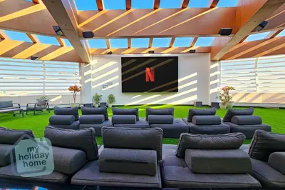 a large living room with a large screen tv at Luxury-Modern Apt with Theatre-Games-Pool-Gym in Dubai