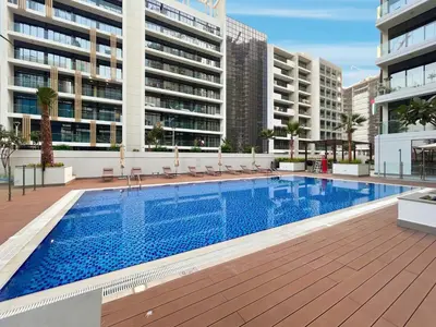 an outdoor swimming pool with chairs and buildings at BLVD Cozy Stay with Balcony View 10mn to Downtown in Dubai