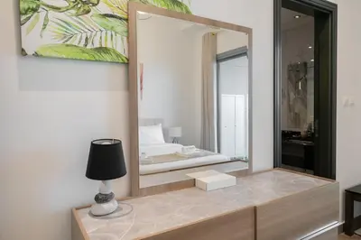 a mirror in a room with a lamp and a bed at Elegant 2BR - Top Amenities - Elite Business Bay in Dubai