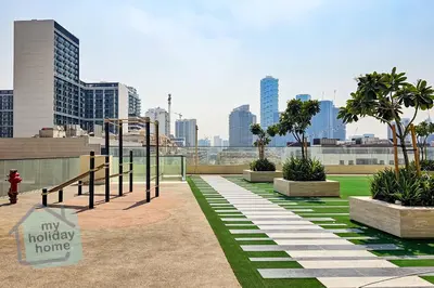 a playground in a park with a city in the background at Modern 1BR Apt - Parking - Gym - Play Area in Dubai
