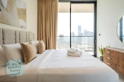 a bedroom with a large bed with a large window at Modern 1BR Apt - Parking - Gym - Play Area in Dubai