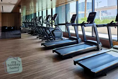 a row of exercise bikes in a gym at Modern 1BR Apt - Parking - Gym - Play Area in Dubai