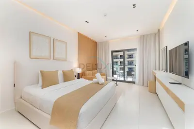 a white bedroom with a large bed and a television at Studio with Seamless Mall Access, Steps from the Bus Stop, Binghatti Stars, Dubai Silicon Oasis by Deluxe Holiday Homes in Dubai
