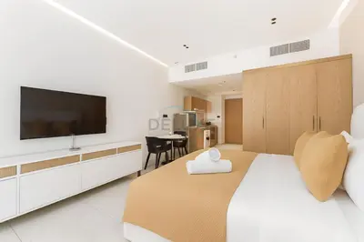 a bedroom with a large bed with a flat screen tv at Studio with Seamless Mall Access, Steps from the Bus Stop, Binghatti Stars, Dubai Silicon Oasis by Deluxe Holiday Homes in Dubai