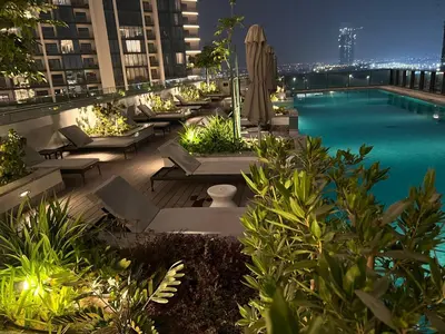 a pool on the roof of a building at night at Deluxe 1BR with maid's room, 10 min to Downtown in Dubai