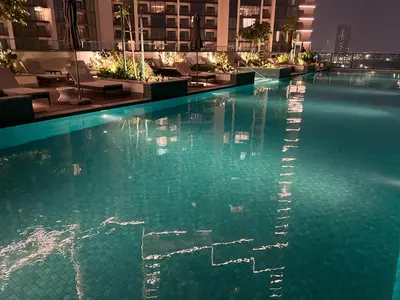 a swimming pool in a hotel at night at Deluxe 1BR with maid's room, 10 min to Downtown in Dubai