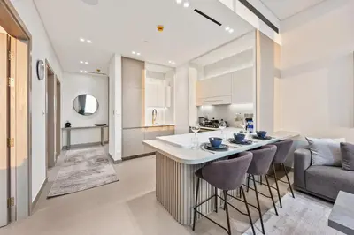 a kitchen and living room with a bar and a couch at Private Pool - Amazing 1BR Apartment in JVC in Dubai