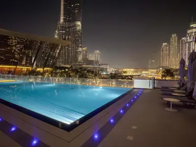 a swimming pool on top of a building with a city skyline at High-Floor Luxury 2BR with Full Burj Khalifa & Fountain Views, Seamless Access to Dubai Mall and Burj Park, Grande, Downtown Dubai by Deluxe Holiday Homes in Dubai