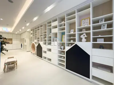 a library with white shelves and a bench in a room at High-Floor Luxury 2BR with Full Burj Khalifa & Fountain Views, Seamless Access to Dubai Mall and Burj Park, Grande, Downtown Dubai by Deluxe Holiday Homes in Dubai
