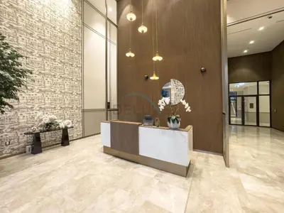 a lobby with a reception desk and a brick wall at High-Floor Luxury 2BR with Full Burj Khalifa & Fountain Views, Seamless Access to Dubai Mall and Burj Park, Grande, Downtown Dubai by Deluxe Holiday Homes in Dubai