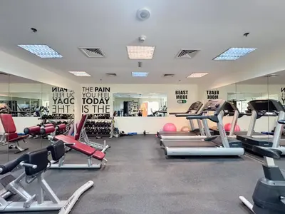 a gym with lots of cardio equipment and mirrors at StayShort - Roomy 2BR in Al Barsha with Balcony - Sleeps 4 in Dubai