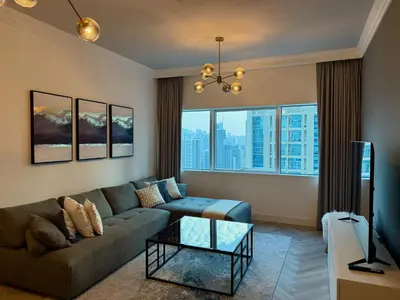 a living room with a couch and a large window at Casa Marina - great views & pool, fully equipped in Dubai