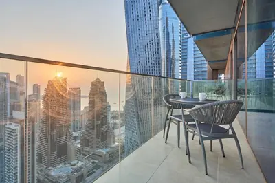 a balcony with two chairs and a table on a building at Luxury High Floor 4 Bedrooms with Marina Views by Stayfinity in Dubai